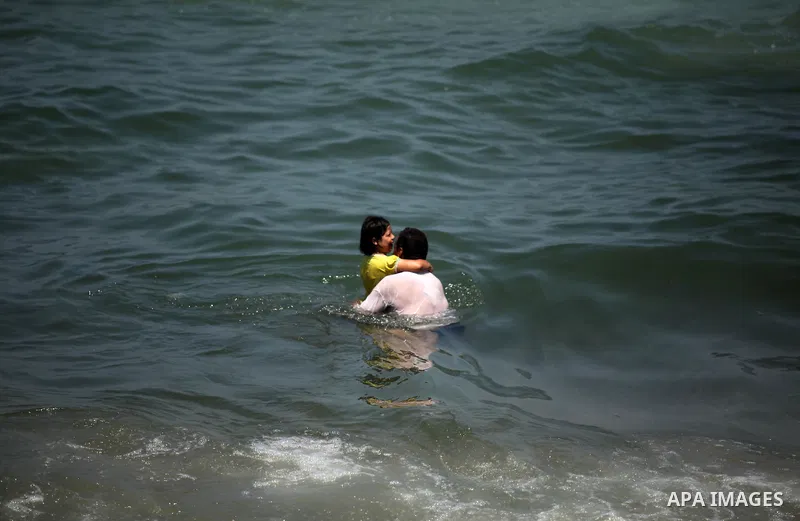 Palestinians swim in the Mediterranean sea on the coast of Gaza city on July 31, 2016. Photo by Ashraf Amra