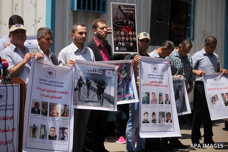 Palestinian Journalists hold banners during a protest calling for stop the Israeli violence against journalists in front of the high commissioner for human rights headquarters in Gaza City, on July 31, 2016. Photo by Ash...