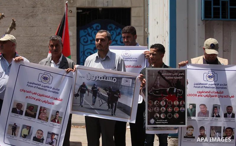 Palestinian Journalists hold banners during a protest calling for stop the Israeli violence against journalists in front of the high commissioner for human rights headquarters in Gaza City, on July 31, 2016. Photo by Ash...