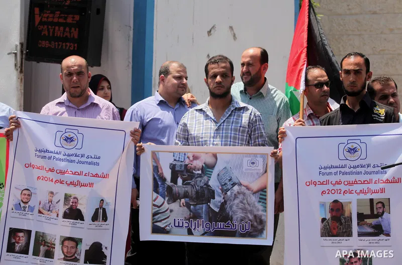 Palestinian Journalists hold banners during a protest calling for stop the Israeli violence against journalists in front of the high commissioner for human rights headquarters in Gaza City, on July 31, 2016. Photo by Ash...