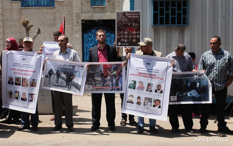 Palestinian Journalists hold banners during a protest calling for stop the Israeli violence against journalists in front of the high commissioner for human rights headquarters in Gaza City, on July 31, 2016. Photo by Ash...