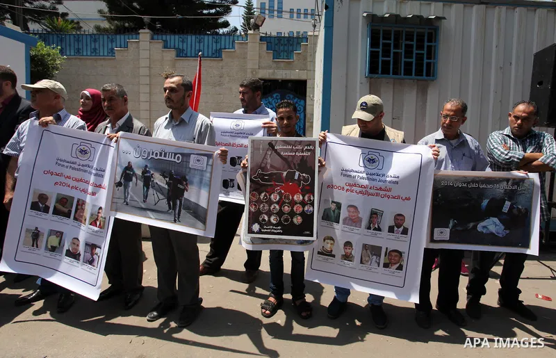 Palestinian Journalists hold banners during a protest calling for stop the Israeli violence against journalists in front of the high commissioner for human rights headquarters in Gaza City, on July 31, 2016. Photo by Ash...