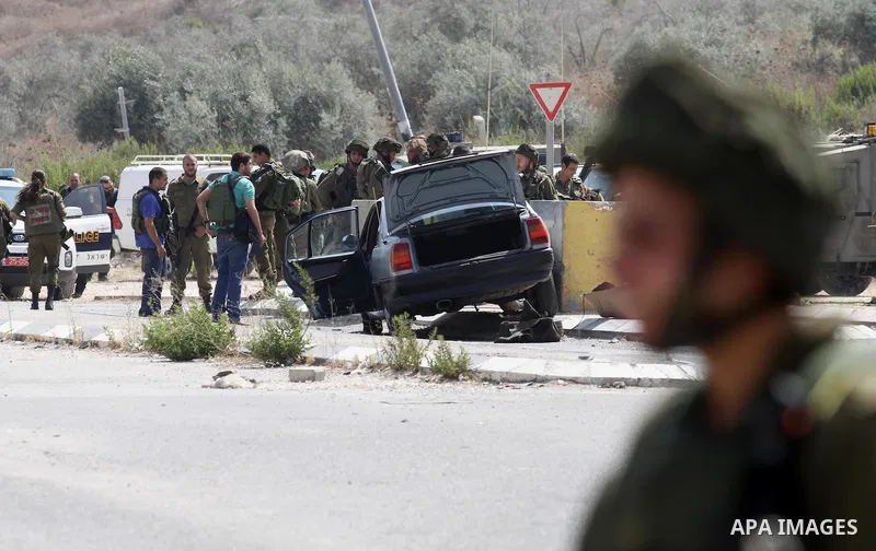 Israeli soldiers gather next to a vehicle belonging to a Palestinian man after he reportedly charged it into a group of soldiers at the Israeli army Hawara checkpoint near the city of Nablus in the occupied West Bank on...