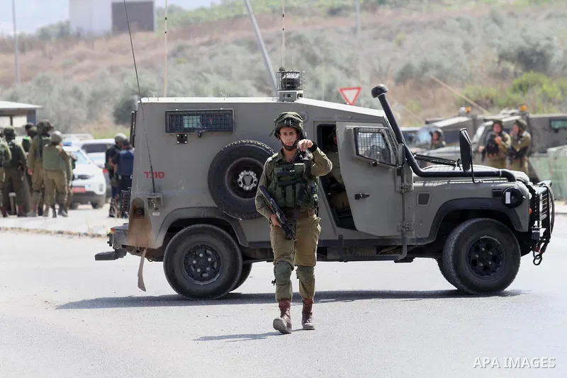 Israeli soldiers gather next to a vehicle belonging to a Palestinian man after he reportedly charged it into a group of soldiers at the Israeli army Hawara checkpoint near the city of Nablus in the occupied West Bank on...