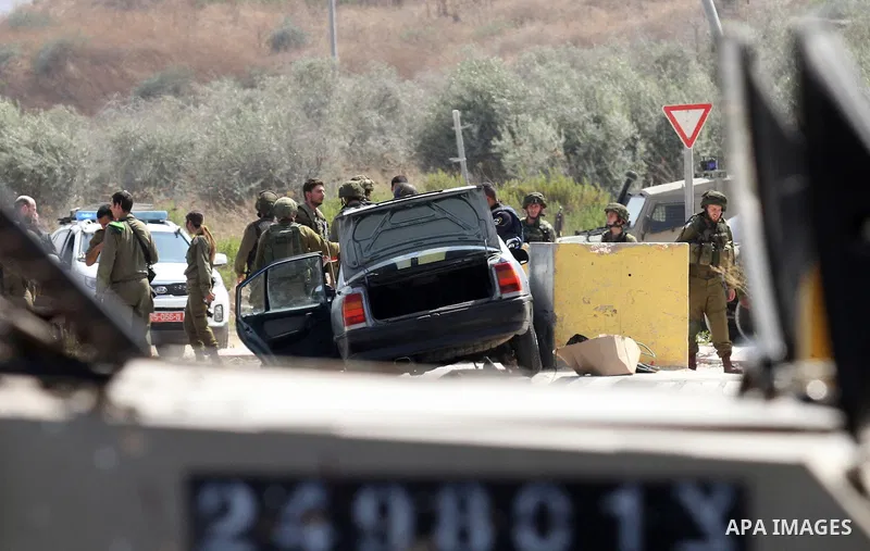 Israeli soldiers gather next to a vehicle belonging to a Palestinian man after he reportedly charged it into a group of soldiers at the Israeli army Hawara checkpoint near the city of Nablus in the occupied West Bank on...