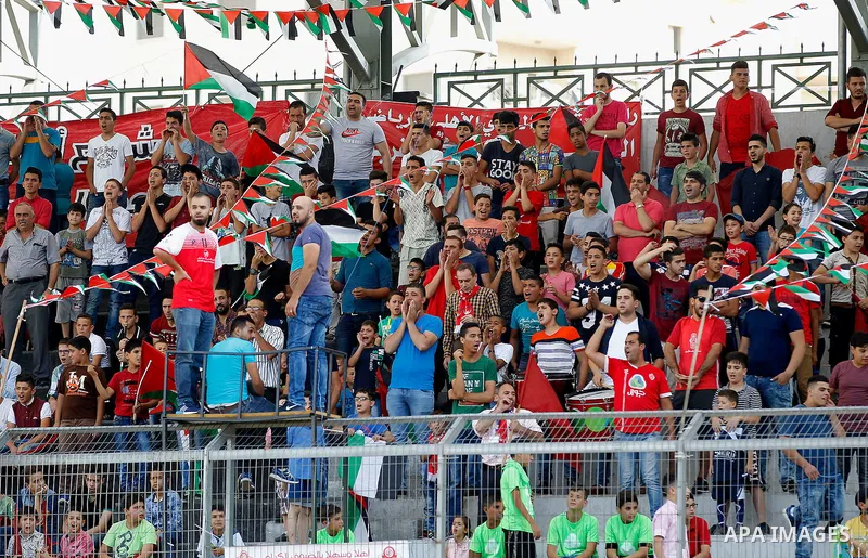Fans of Hebron's football club Ahly al-Khalil cheer before a second leg match against Shabab Khan Yunis for the Palestinian Cup final on August 2, 2016 at Hussein Bin Ali Stadium in the West Bank city of Hebron. The matc...