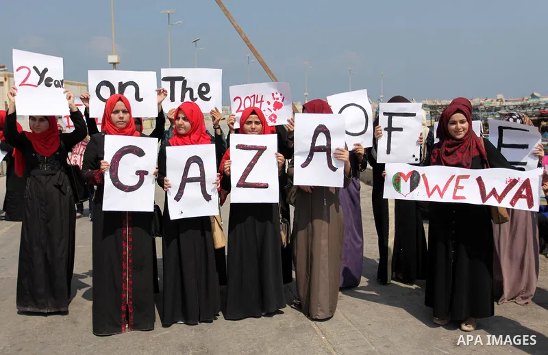 Palestinian girls hold banners during a protest to mark the second anniversary of the 50-day Israeli war on Gaza Strip last summer, in Gaza seaport Aug. 03, 2016. July 8th marks the two-year anniversary of the war betwee...