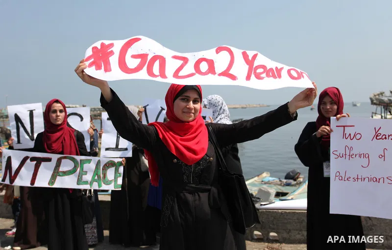 Palestinian girls hold banners during a protest to mark the second anniversary of the 50-day Israeli war on Gaza Strip last summer, in Gaza seaport Aug. 03, 2016. July 8th marks the two-year anniversary of the war betwee...