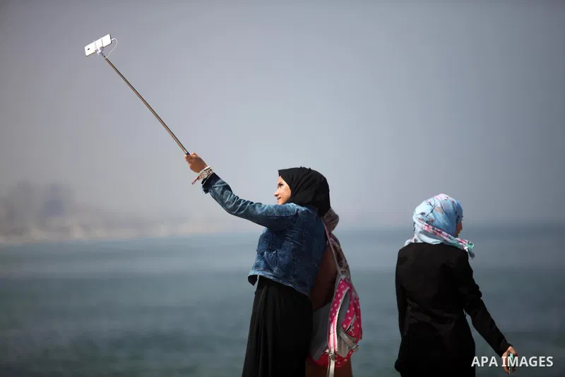 Palestinian girls take a selfie, in Gaza seaport Aug. 03, 2016. Photo by Ashraf Amra
