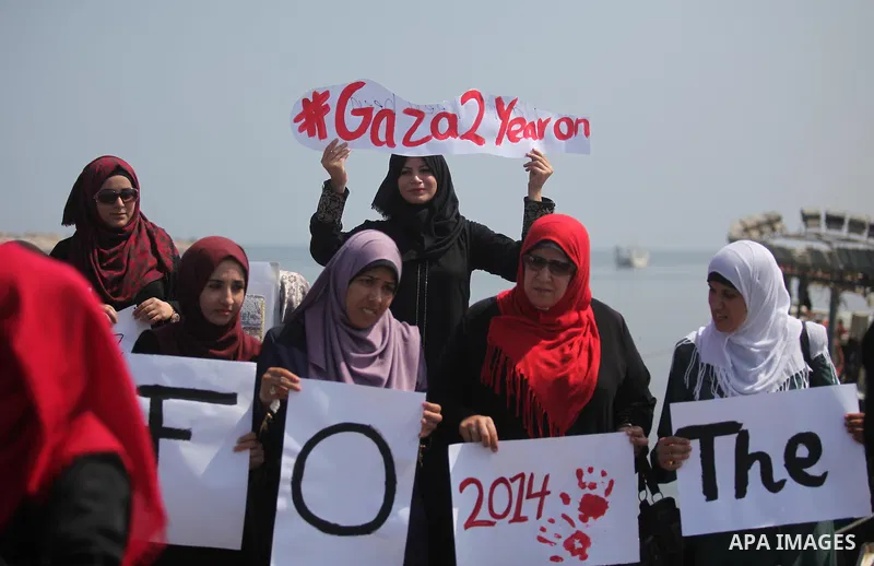 Palestinian girls hold banners during a protest to mark the second anniversary of the 50-day Israeli war on Gaza Strip last summer, in Gaza seaport Aug. 03, 2016. July 8th marks the two-year anniversary of the war betwee...
