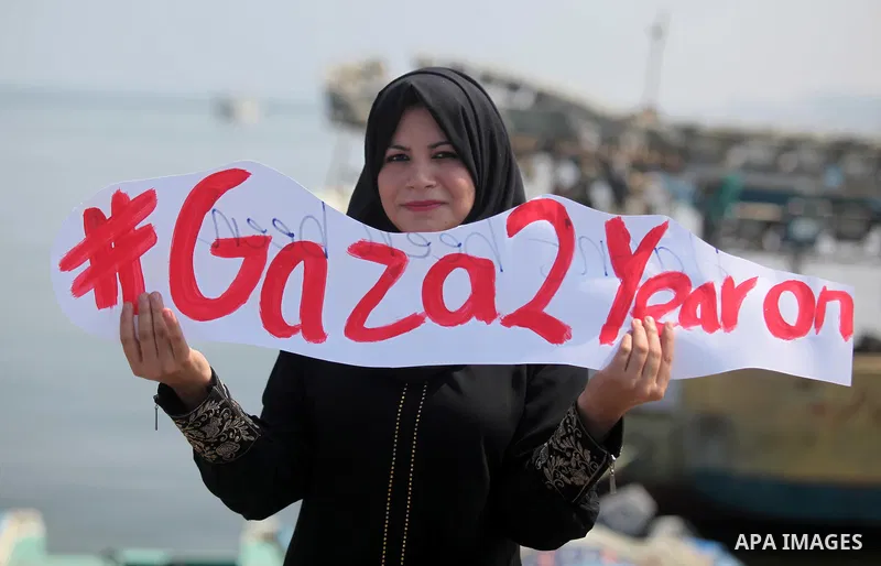 Palestinian girls hold banners during a protest to mark the second anniversary of the 50-day Israeli war on Gaza Strip last summer, in Gaza seaport Aug. 03, 2016. July 8th marks the two-year anniversary of the war betwee...
