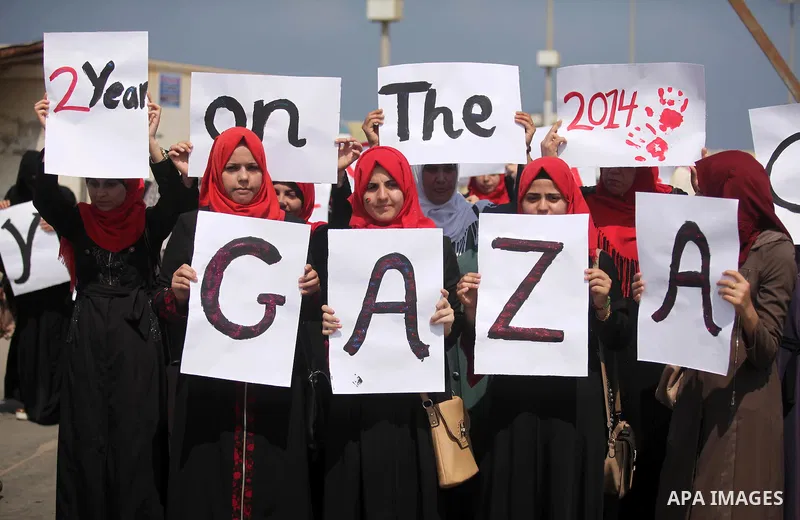 Palestinian girls hold banners during a protest to mark the second anniversary of the 50-day Israeli war on Gaza Strip last summer, in Gaza seaport Aug. 03, 2016. July 8th marks the two-year anniversary of the war betwee...