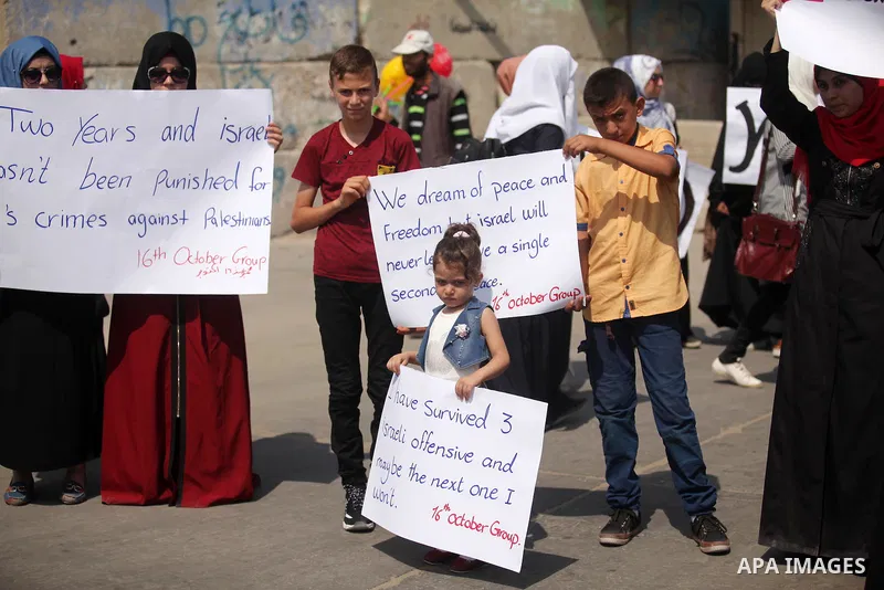 Palestinian girls hold banners during a protest to mark the second anniversary of the 50-day Israeli war on Gaza Strip last summer, in Gaza seaport Aug. 03, 2016. July 8th marks the two-year anniversary of the war betwee...