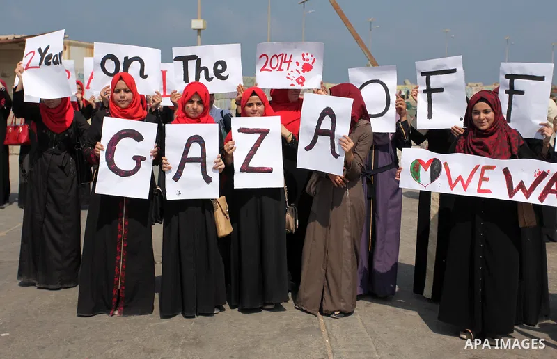 Palestinian girls hold banners during a protest to mark the second anniversary of the 50-day Israeli war on Gaza Strip last summer, in Gaza seaport Aug. 03, 2016. July 8th marks the two-year anniversary of the war betwee...