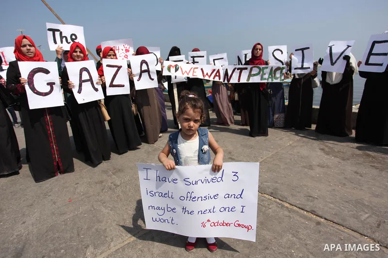 Palestinian girls hold banners during a protest to mark the second anniversary of the 50-day Israeli war on Gaza Strip last summer, in Gaza seaport Aug. 03, 2016. July 8th marks the two-year anniversary of the war betwee...