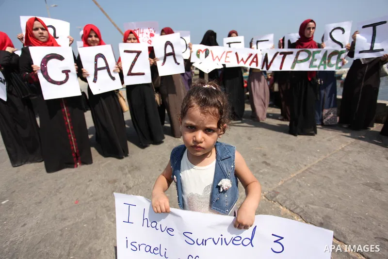 Palestinian girls hold banners during a protest to mark the second anniversary of the 50-day Israeli war on Gaza Strip last summer, in Gaza seaport Aug. 03, 2016. July 8th marks the two-year anniversary of the war betwee...