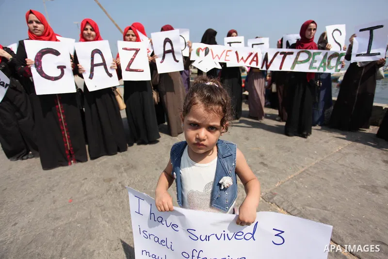 Palestinian girls hold banners during a protest to mark the second anniversary of the 50-day Israeli war on Gaza Strip last summer, in Gaza seaport Aug. 03, 2016. July 8th marks the two-year anniversary of the war betwee...