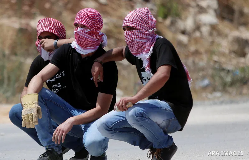 Palestinian protesters look on during clashes with Israeli security forces following a demonstration against the detention of Bilal Kayed a Palestinian prisoner on hunger strike, outside the compound of the Israeli-run O...