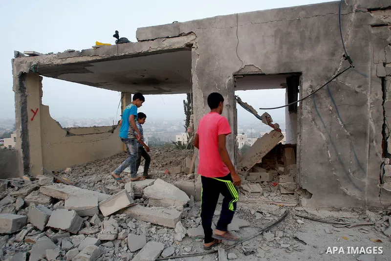 Relatives inspect the family house of Palestinian assailant Mohammad Makhamreh after it was partially blown up by Israeli troops in the West Bank village of Yatta, south of Hebron August 4, 2016. Photo by Wisam Hashlamou...