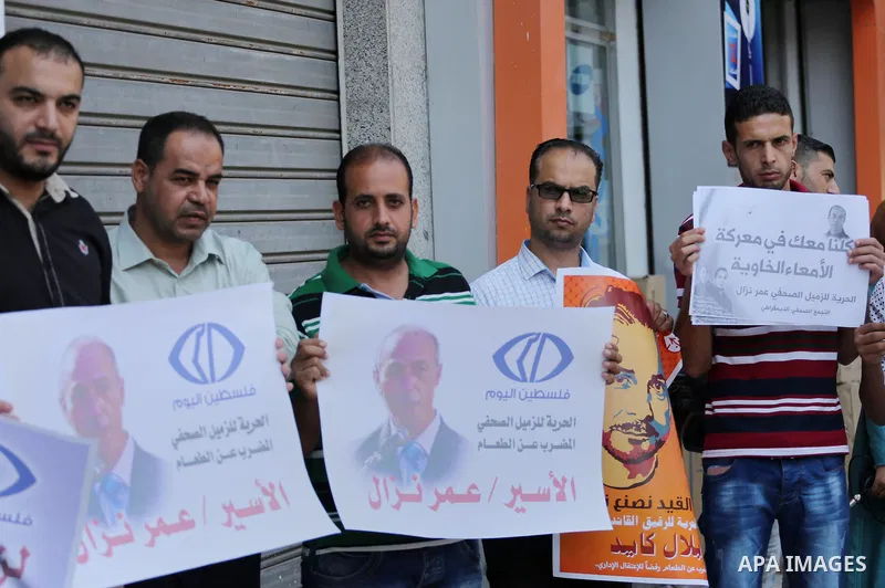Palestinian journalists take part during a protest calling for the release of Palestinian journalist Omar Nazal who is on hunger strike in Gaza city on Aug. 04, 2016. Photo by Mohammed Asad
