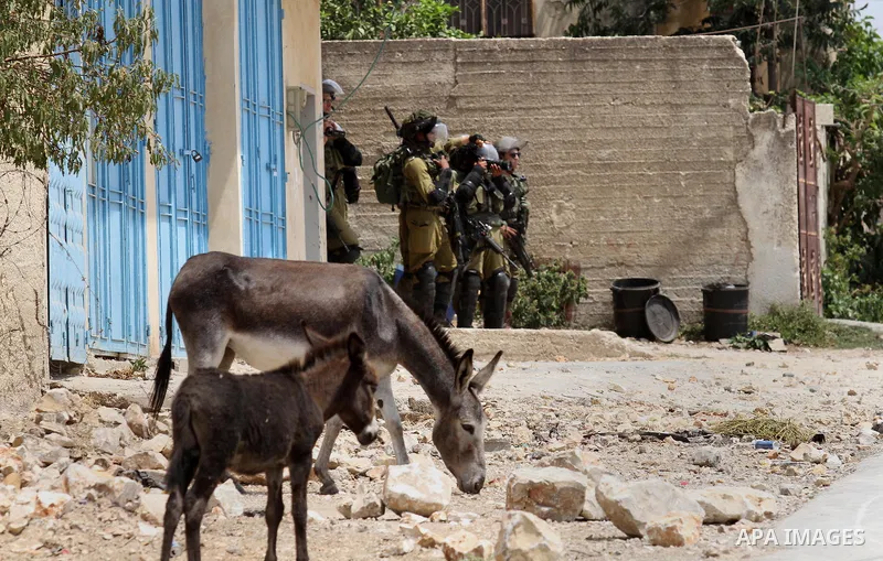 Israeli security forces take pictures during clashes with Palestinian protesters following the weekly demonstration against the expropriation of Palestinian land by Israel in the village of Kfar Qaddum, near Nablus, in t...