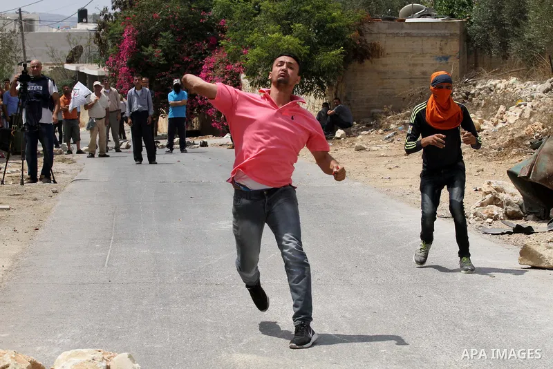 Palestinian protestors throw stones towards Israeli security forces during clashes following the weekly demonstration against the expropriation of Palestinian land by Israel in the village of Kfar Qaddum, near Nablus, in...