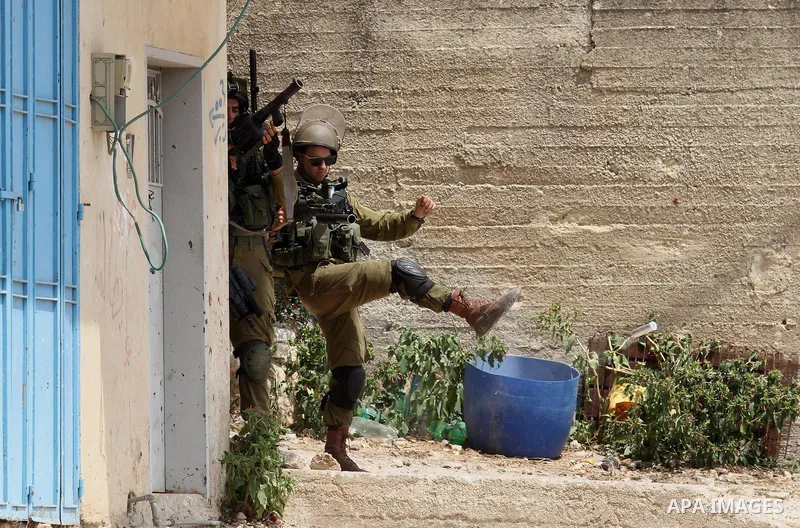 A member of Israeli security forces kick a tear gas canister towards Palestinian protesters during clashes following the weekly demonstration against the expropriation of Palestinian land by Israel in the village of Kfar...