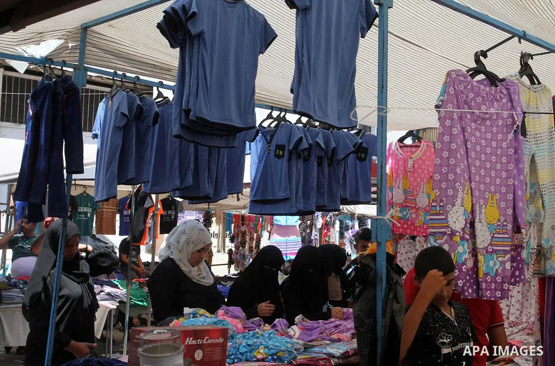 Palestinians shop during preparation for the new school year at a market in Rafah in the southern Gaza strip on Aug 6, 2016. Photo by Abed Rahim Khatib
