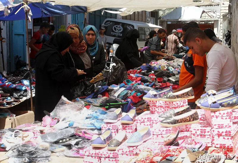 Palestinians shop during preparation for the new school year at a market in Rafah in the southern Gaza strip on Aug 6, 2016. Photo by Abed Rahim Khatib