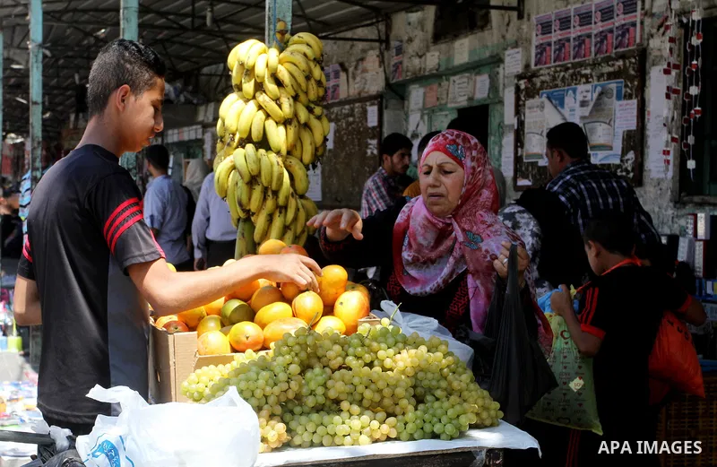 Palestinians shop at a market in Rafah in the southern Gaza strip on Aug 6, 2016. Photo by Abed Rahim Khatib