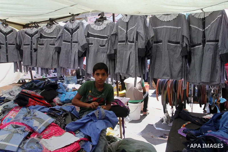 Palestinians shop during preparation for the new school year at a market in Rafah in the southern Gaza strip on Aug 6, 2016. Photo by Abed Rahim Khatib