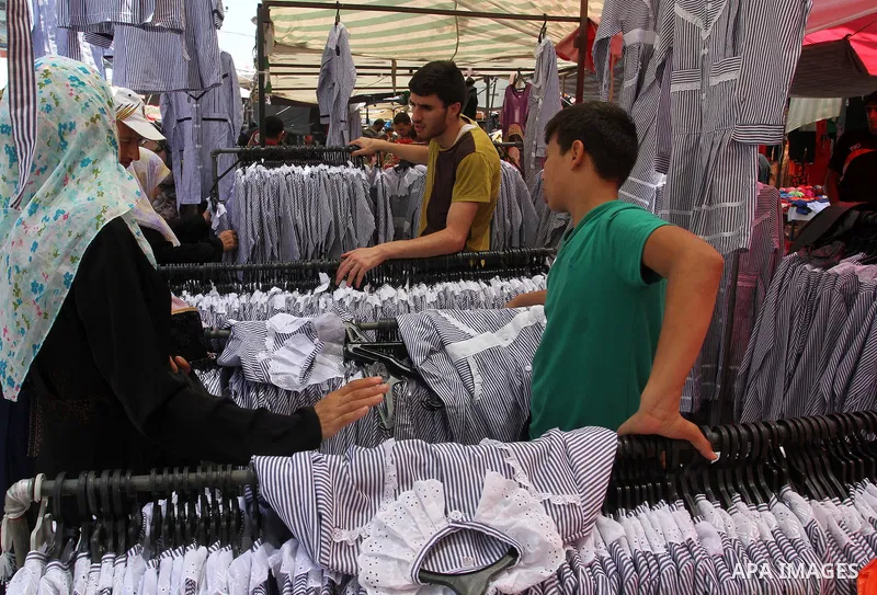 Palestinians shop during preparation for the new school year at a market in Rafah in the southern Gaza strip on Aug 6, 2016. Photo by Abed Rahim Khatib