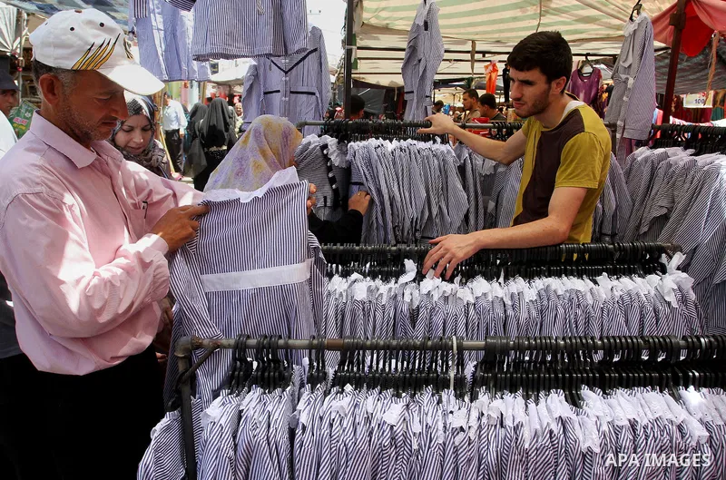 Palestinians shop during preparation for the new school year at a market in Rafah in the southern Gaza strip on Aug 6, 2016. Photo by Abed Rahim Khatib