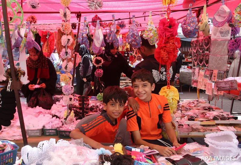 Palestinians shop during preparation for the new school year at a market in Rafah in the southern Gaza strip on Aug 6, 2016. Photo by Abed Rahim Khatib
