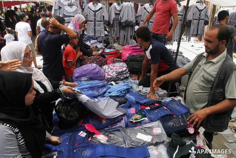 Palestinians shop during preparation for the new school year at a market in Rafah in the southern Gaza strip on Aug 6, 2016. Photo by Abed Rahim Khatib