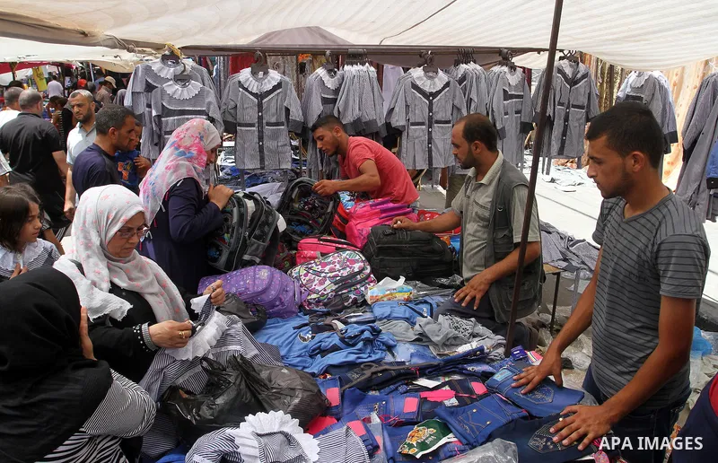 Palestinians shop during preparation for the new school year at a market in Rafah in the southern Gaza strip on Aug 6, 2016. Photo by Abed Rahim Khatib