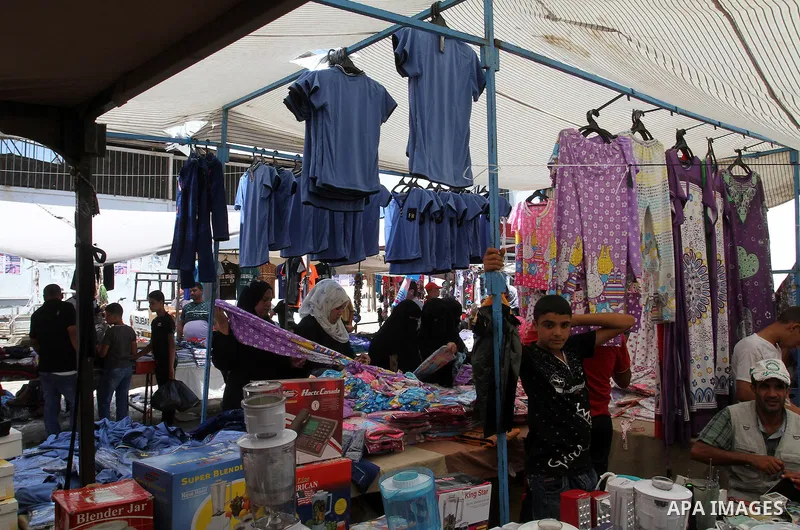 Palestinians shop during preparation for the new school year at a market in Rafah in the southern Gaza strip on Aug 6, 2016. Photo by Abed Rahim Khatib