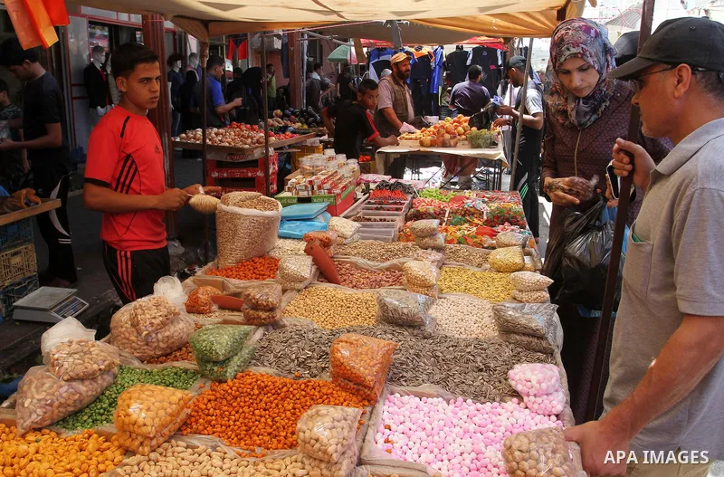 Palestinians shop at a market in Rafah in the southern Gaza strip on Aug 6, 2016. Photo by Abed Rahim Khatib