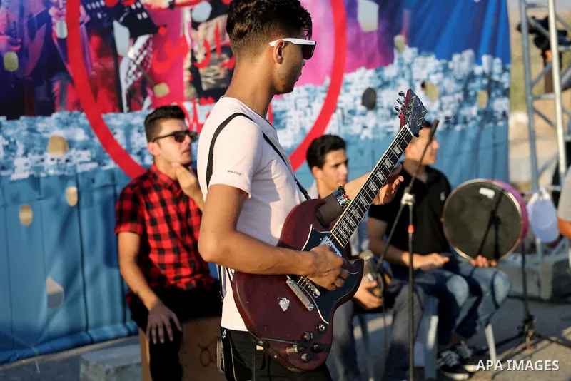 Palestinian band Dawaween, who were denied access to perform at a festival in Jerusalem, deliver a performance as part of a protest against the denial in Beit Hanun, near the Erez crossing point with Israel, in the north...