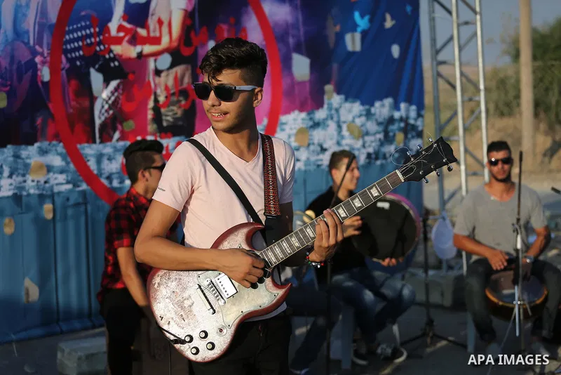 Palestinian band Dawaween, who were denied access to perform at a festival in Jerusalem, deliver a performance as part of a protest against the denial in Beit Hanun, near the Erez crossing point with Israel, in the north...