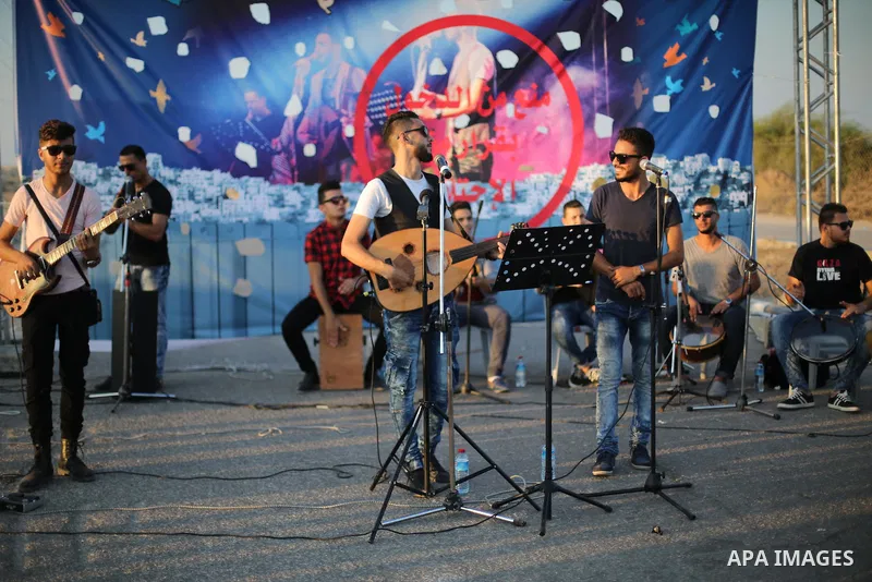 Palestinian band Dawaween, who were denied access to perform at a festival in Jerusalem, deliver a performance as part of a protest against the denial in Beit Hanun, near the Erez crossing point with Israel, in the north...