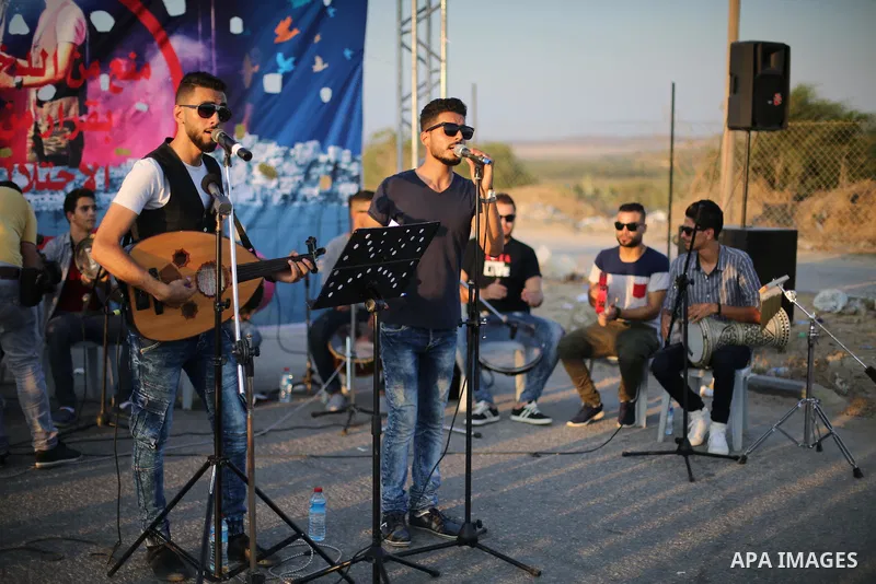 Palestinian band Dawaween, who were denied access to perform at a festival in Jerusalem, deliver a performance as part of a protest against the denial in Beit Hanun, near the Erez crossing point with Israel, in the north...