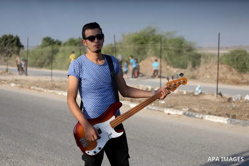 Palestinian band Dawaween, who were denied access to perform at a festival in Jerusalem, deliver a performance as part of a protest against the denial in Beit Hanun, near the Erez crossing point with Israel, in the north...