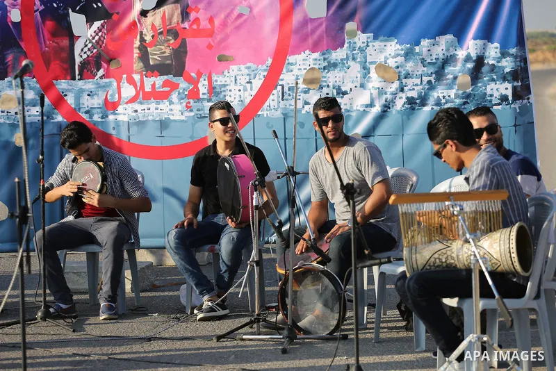 Palestinian band Dawaween, who were denied access to perform at a festival in Jerusalem, deliver a performance as part of a protest against the denial in Beit Hanun, near the Erez crossing point with Israel, in the north...