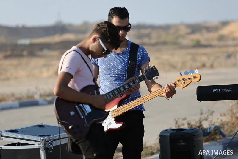 Palestinian band Dawaween, who were denied access to perform at a festival in Jerusalem, deliver a performance as part of a protest against the denial in Beit Hanun, near the Erez crossing point with Israel, in the north...