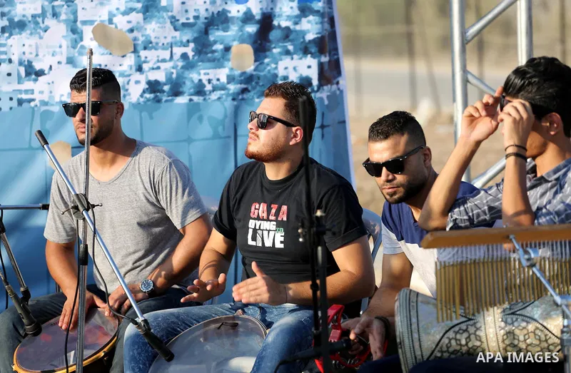 Palestinian band Dawaween, who were denied access to perform at a festival in Jerusalem, deliver a performance as part of a protest against the denial in Beit Hanun, near the Erez crossing point with Israel, in the north...