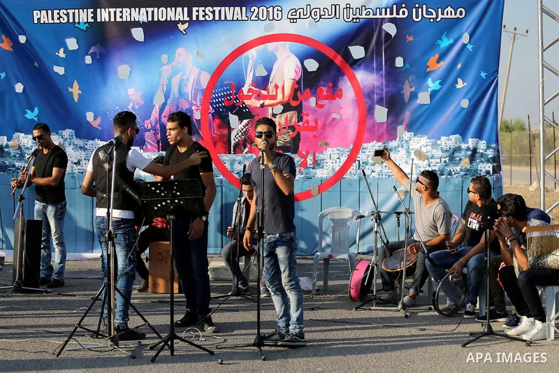 Palestinian band Dawaween, who were denied access to perform at a festival in Jerusalem, deliver a performance as part of a protest against the denial in Beit Hanun, near the Erez crossing point with Israel, in the north...