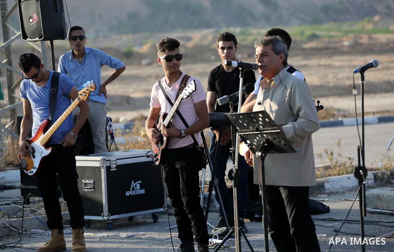 Palestinian band Dawaween, who were denied access to perform at a festival in Jerusalem, deliver a performance as part of a protest against the denial in Beit Hanun, near the Erez crossing point with Israel, in the north...