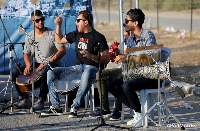 Palestinian band Dawaween, who were denied access to perform at a festival in Jerusalem, deliver a performance as part of a protest against the denial in Beit Hanun, near the Erez crossing point with Israel, in the north...