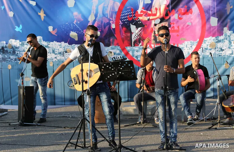 Palestinian band Dawaween, who were denied access to perform at a festival in Jerusalem, deliver a performance as part of a protest against the denial in Beit Hanun, near the Erez crossing point with Israel, in the north...